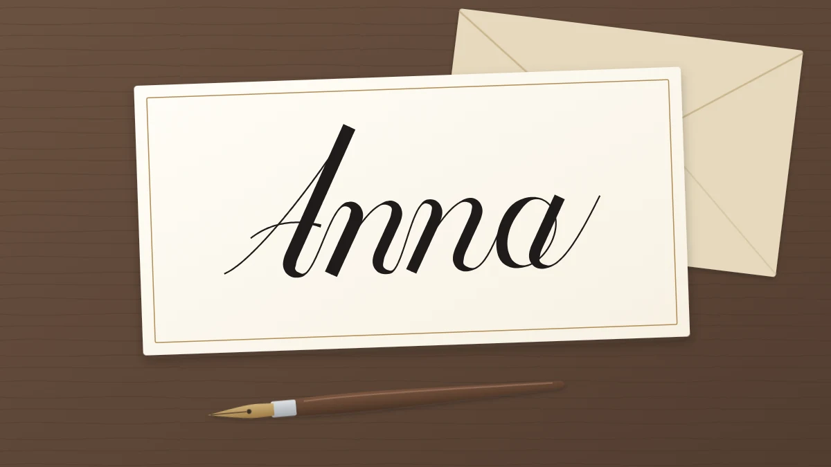 A small ivory card with the name Anna in script, a simple capital A and connected lowercase letters, beside a pointed pen